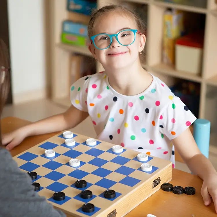 Girl smiling at camera with checkers board.