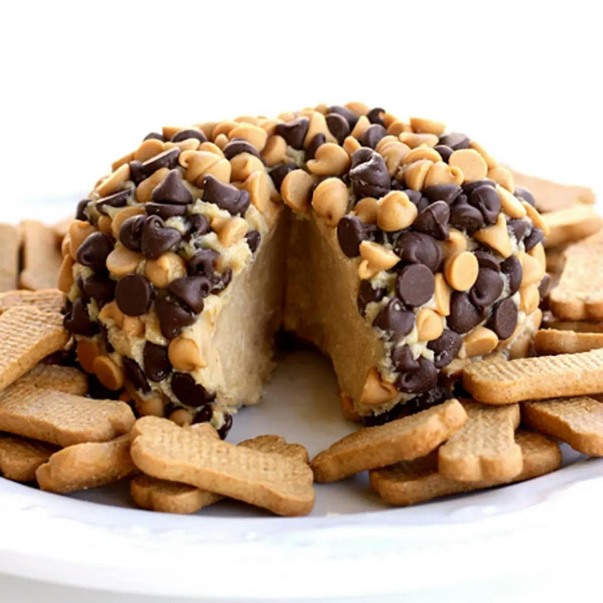 A peanut butter ball studded with chocolate chips, on a Christmas dessert charcuterie board.