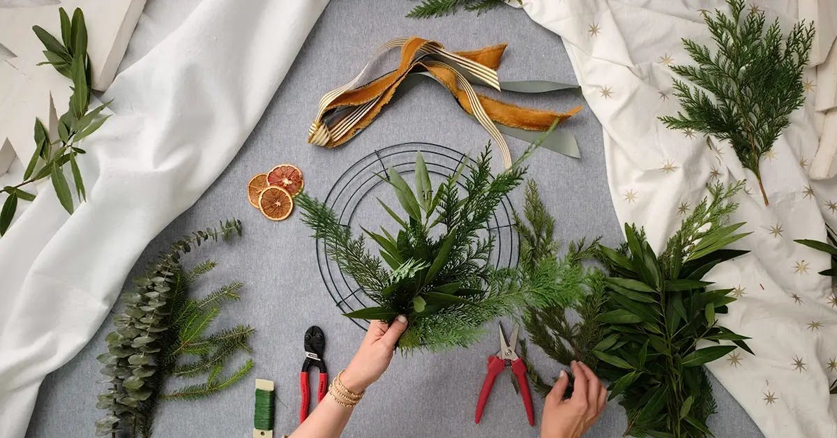 Clipping greens into small pieces ready to be added to a holiday wreath.