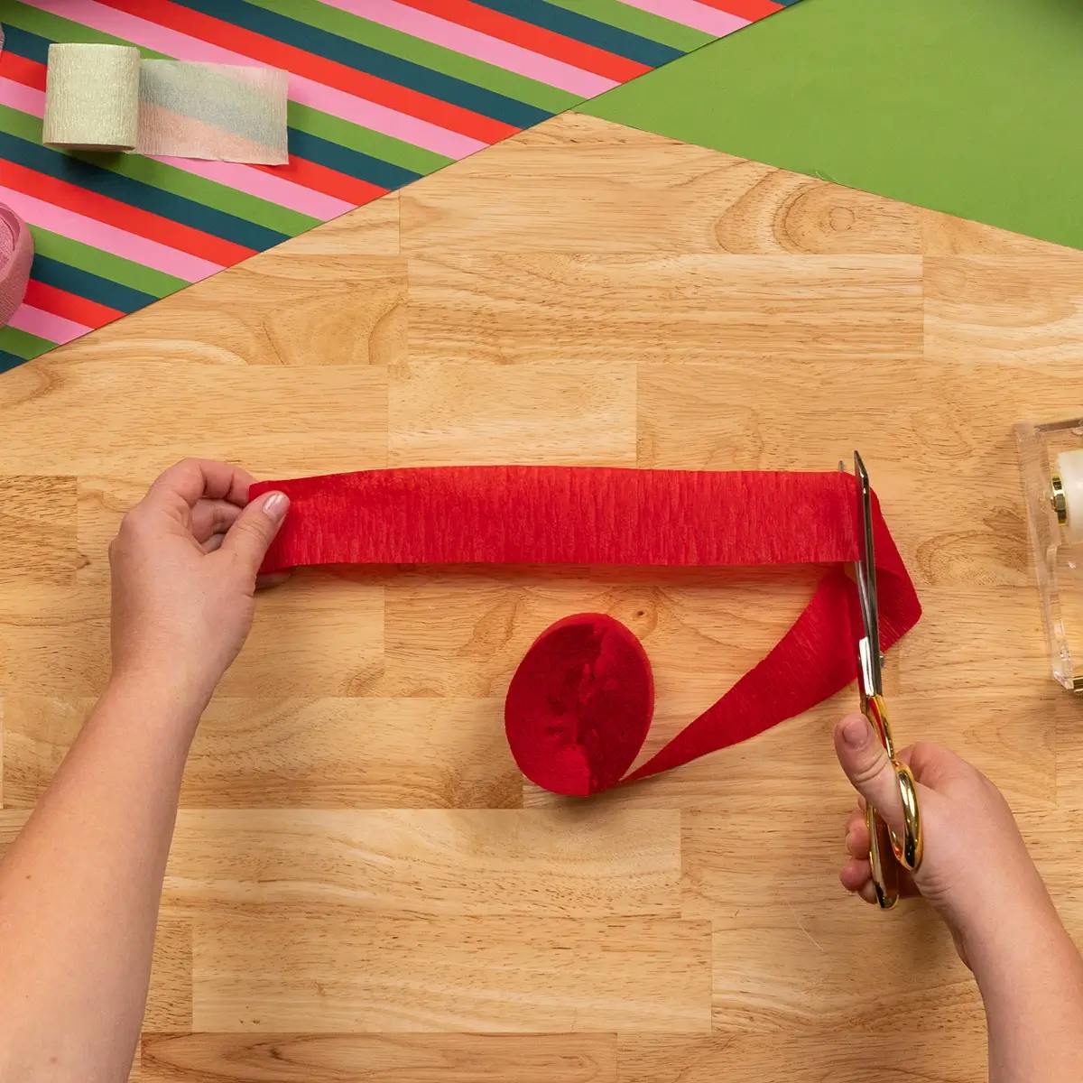 Cutting strips of crepe paper ready to wrap a mug as a gift.