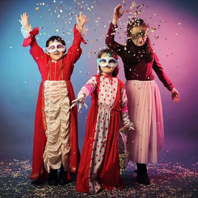 Three children dressed in dress-up costumes