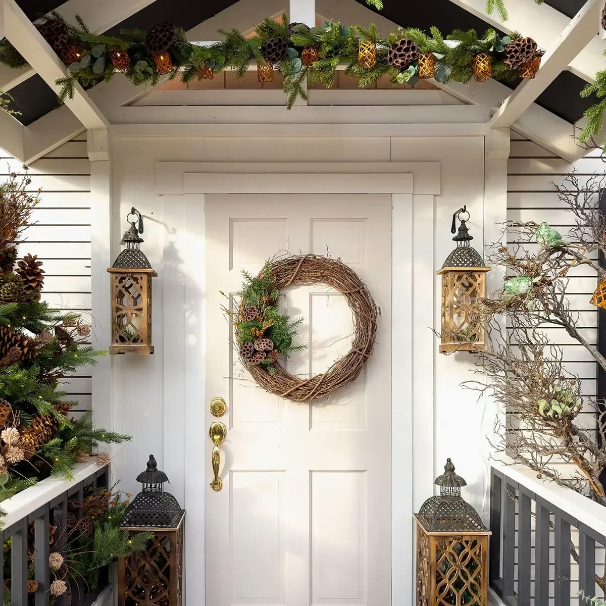 Natural Christmas porch decorations on a white porch.