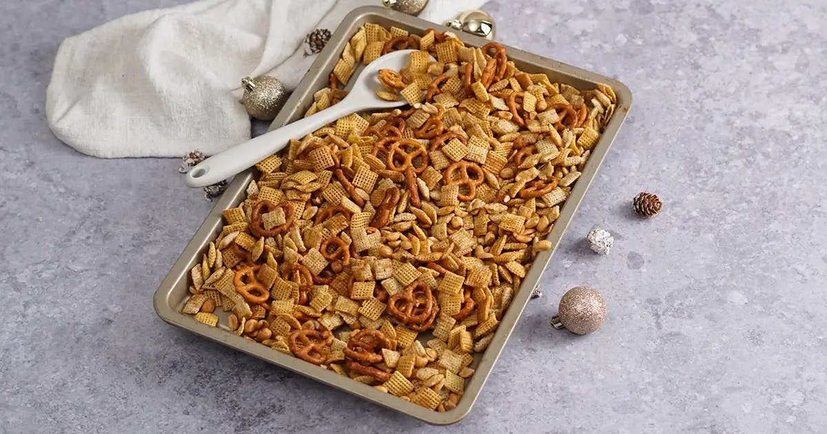 Savory gluten-free chex mix on a baking tray, ready to go into the oven.