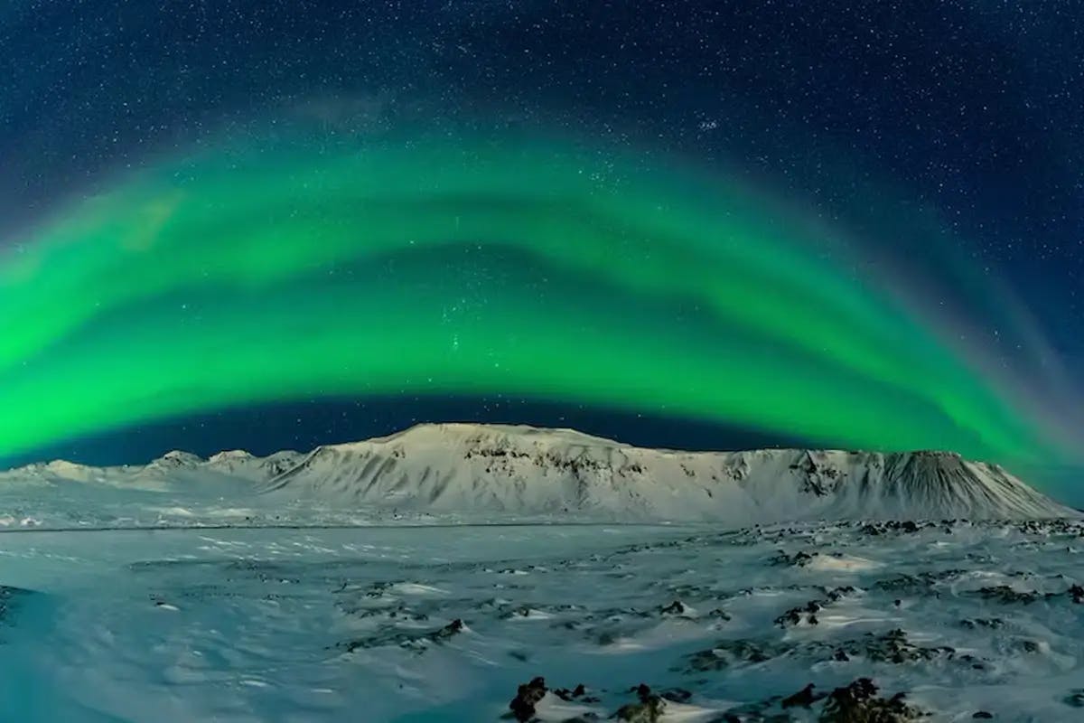 Multi-tiered green arc of The Northern lights over Reykjavik, Iceland.