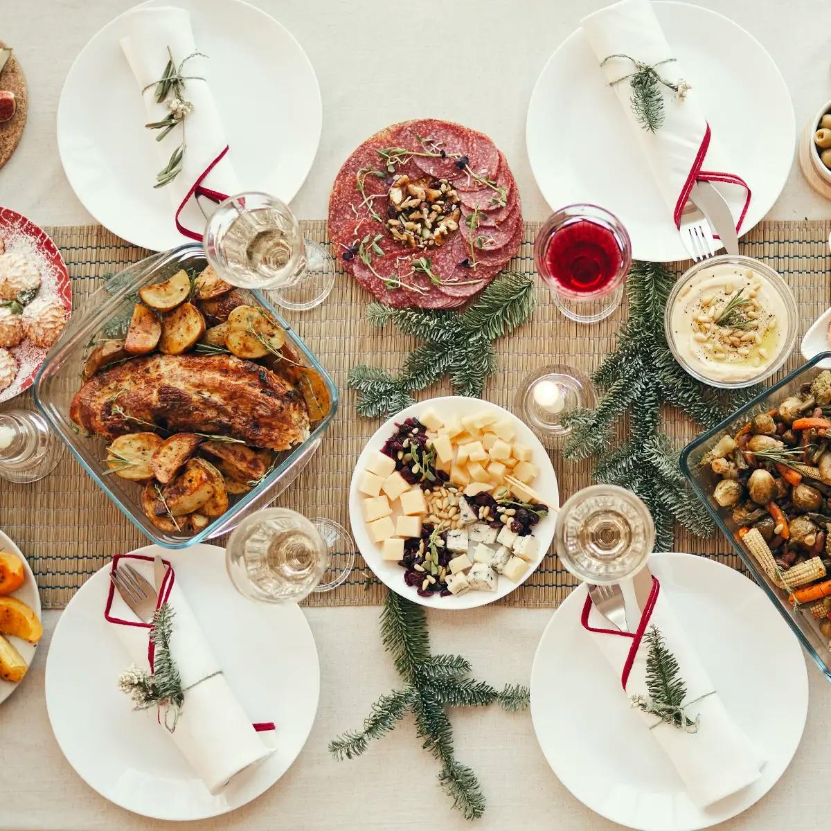 Top view of a wide variety of delicious homemade food on a beautiful Christmas dining table decorated with fir branches.