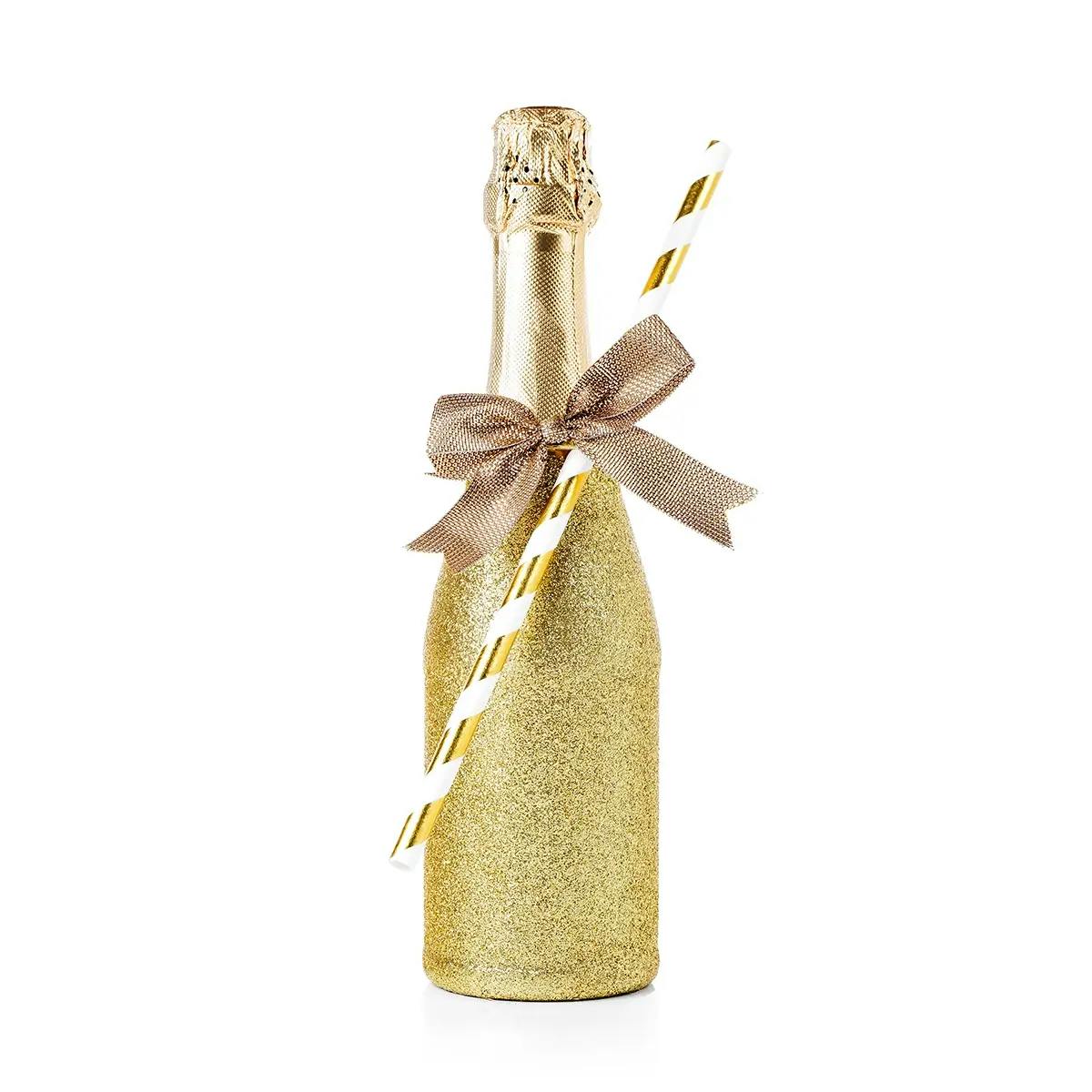 A wine bottle dipped in glitter and tied with ribbon.