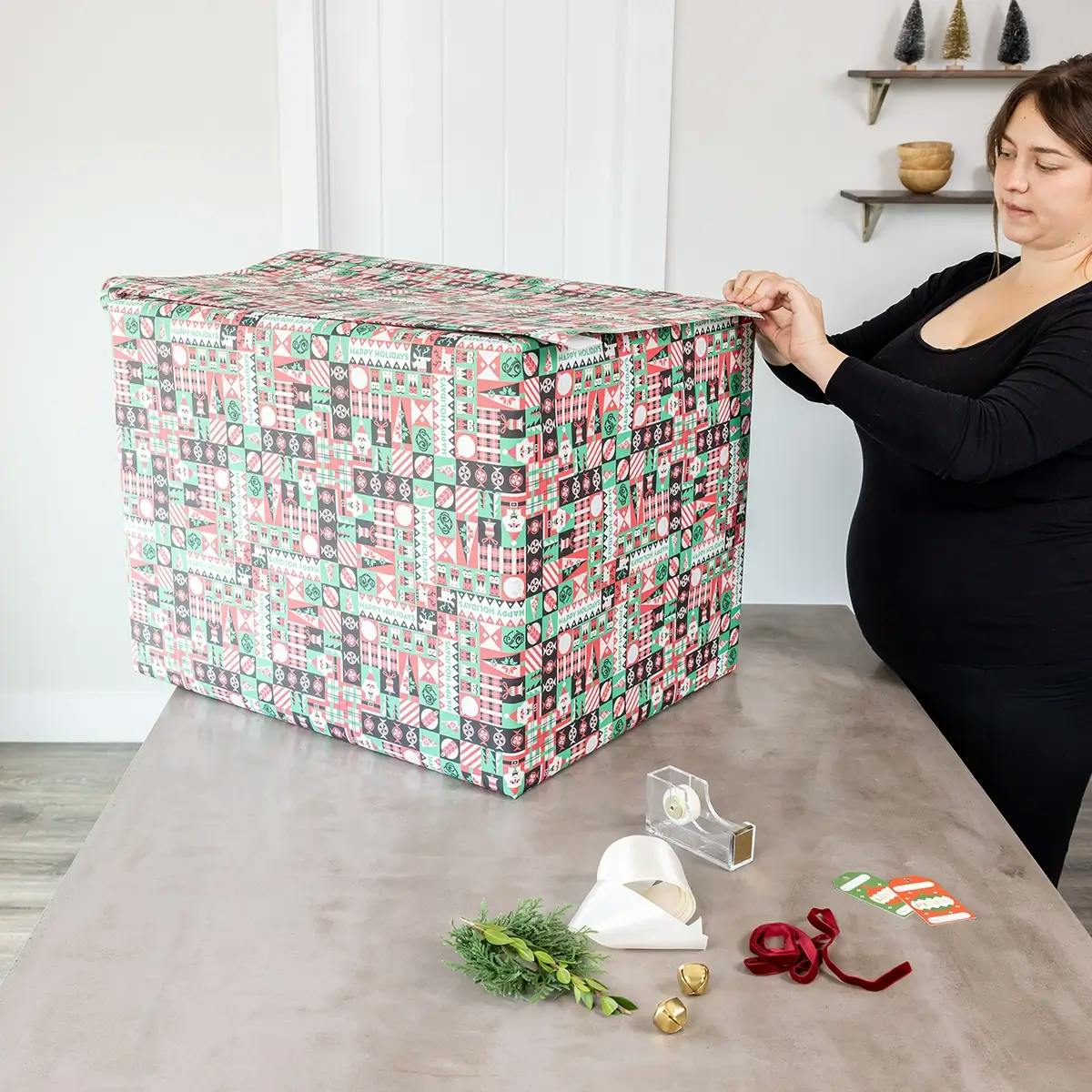 Covering a large box with wrapping paper.
