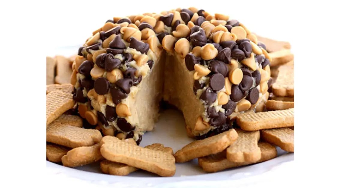 A peanut butter ball studded with chocolate chips, on a Christmas dessert charcuterie board.
