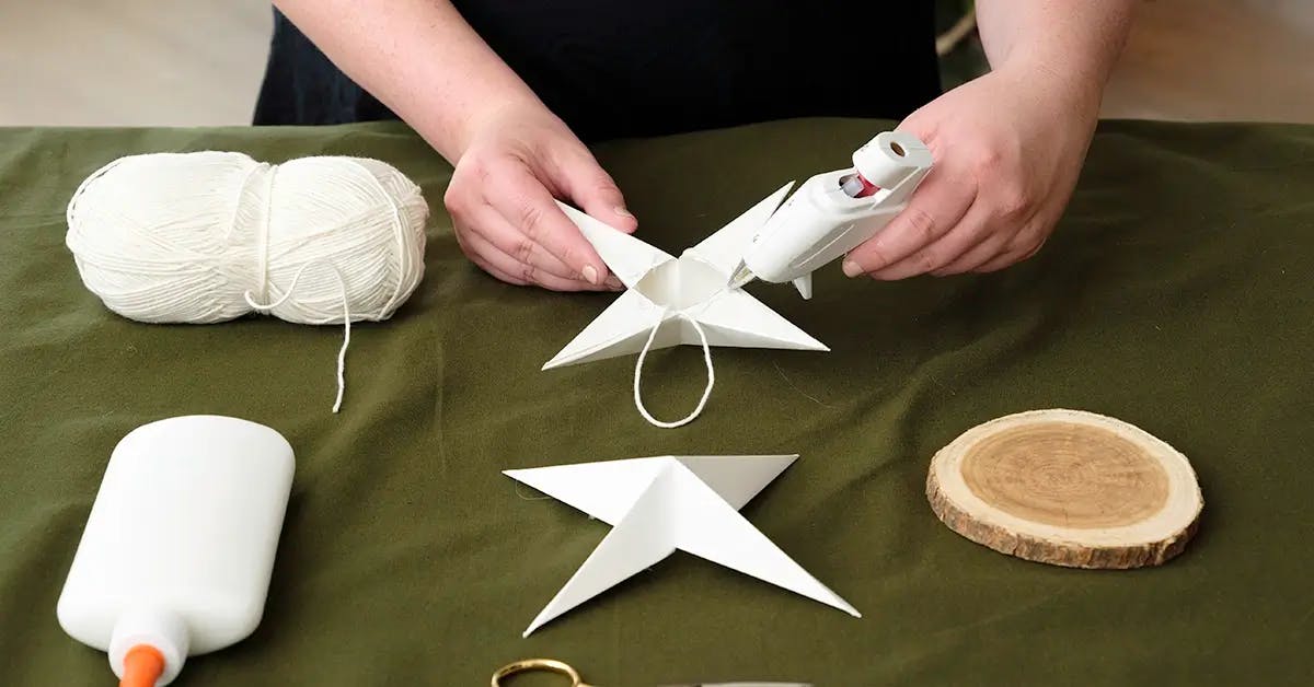 Adding twine to the center of a paper star tree topper.