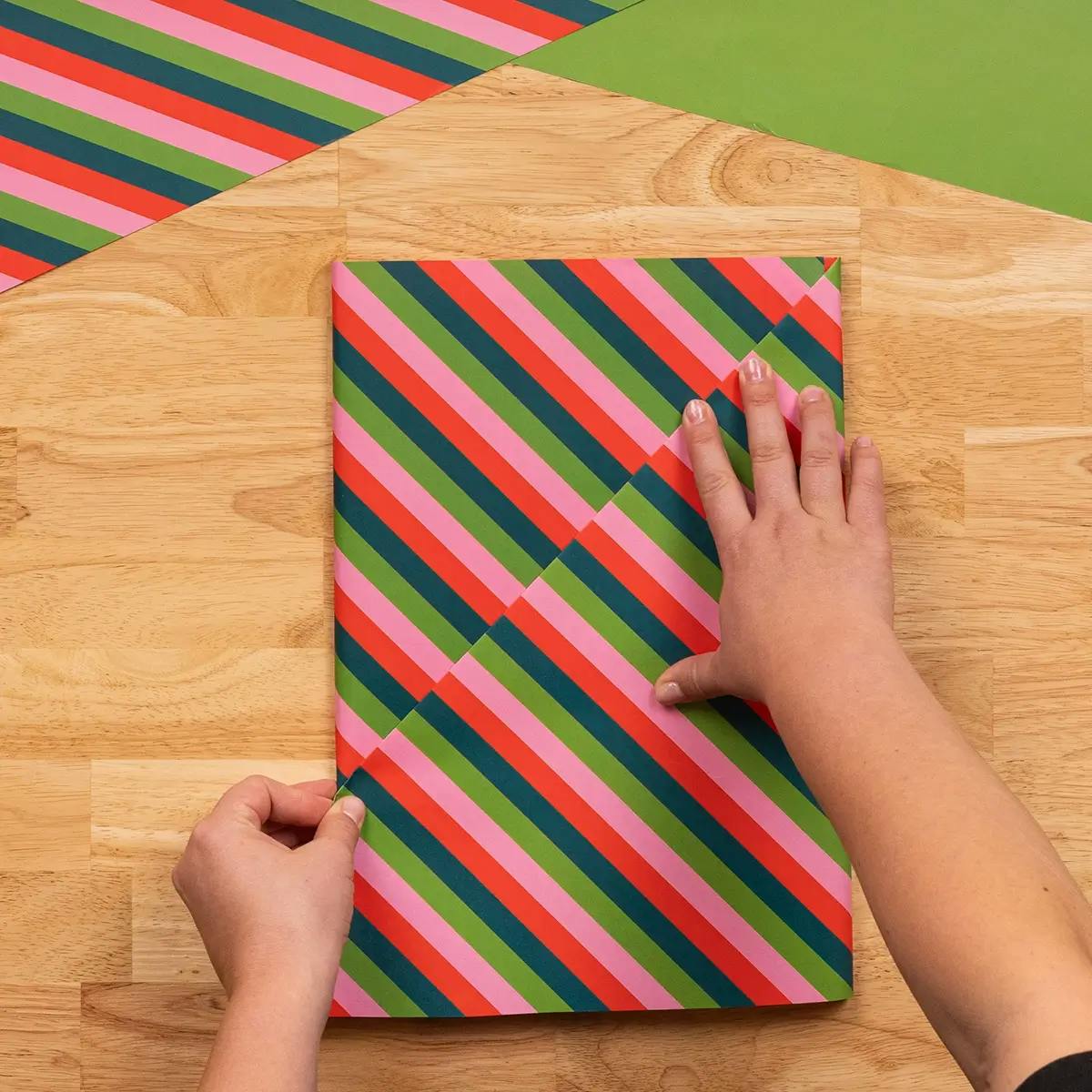 Making a fold in the wrapping paper to contain tags, floral accompaniments, and other decoration.