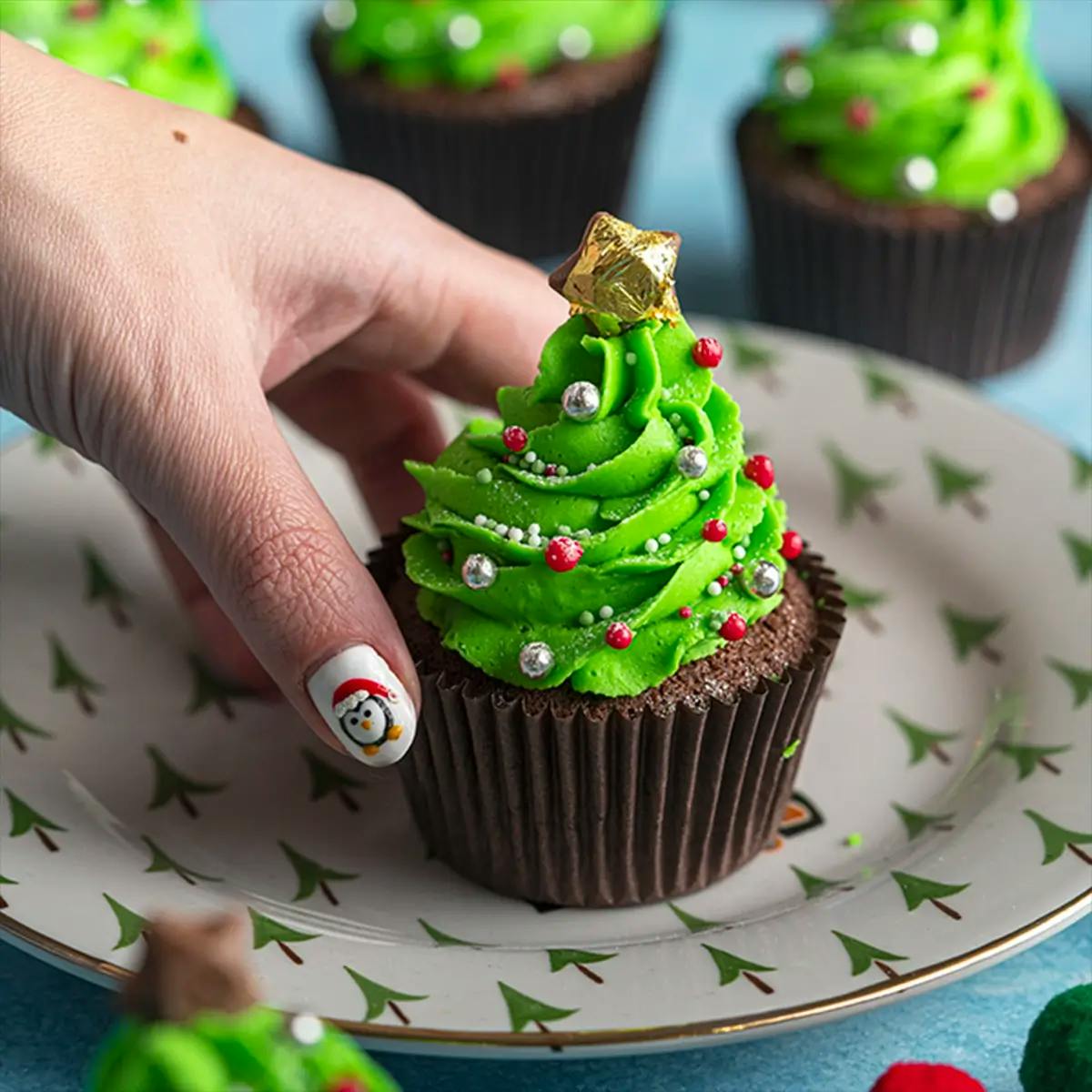 A glute-free chocolate cupcake with green frosting shaped like a Christmas tree.