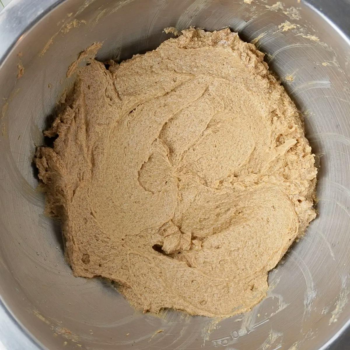 Folding dry flour mixture to batter in a vegan chocolate chip cookie recipe.