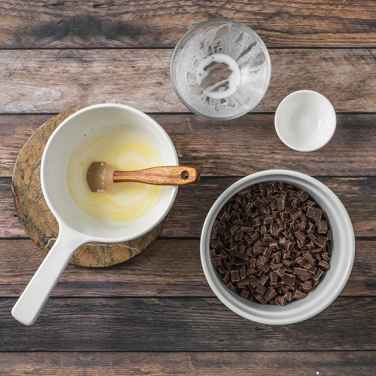 Cream, butter and chocolate in bowls, in a recipe for holiday chocolate truffles.