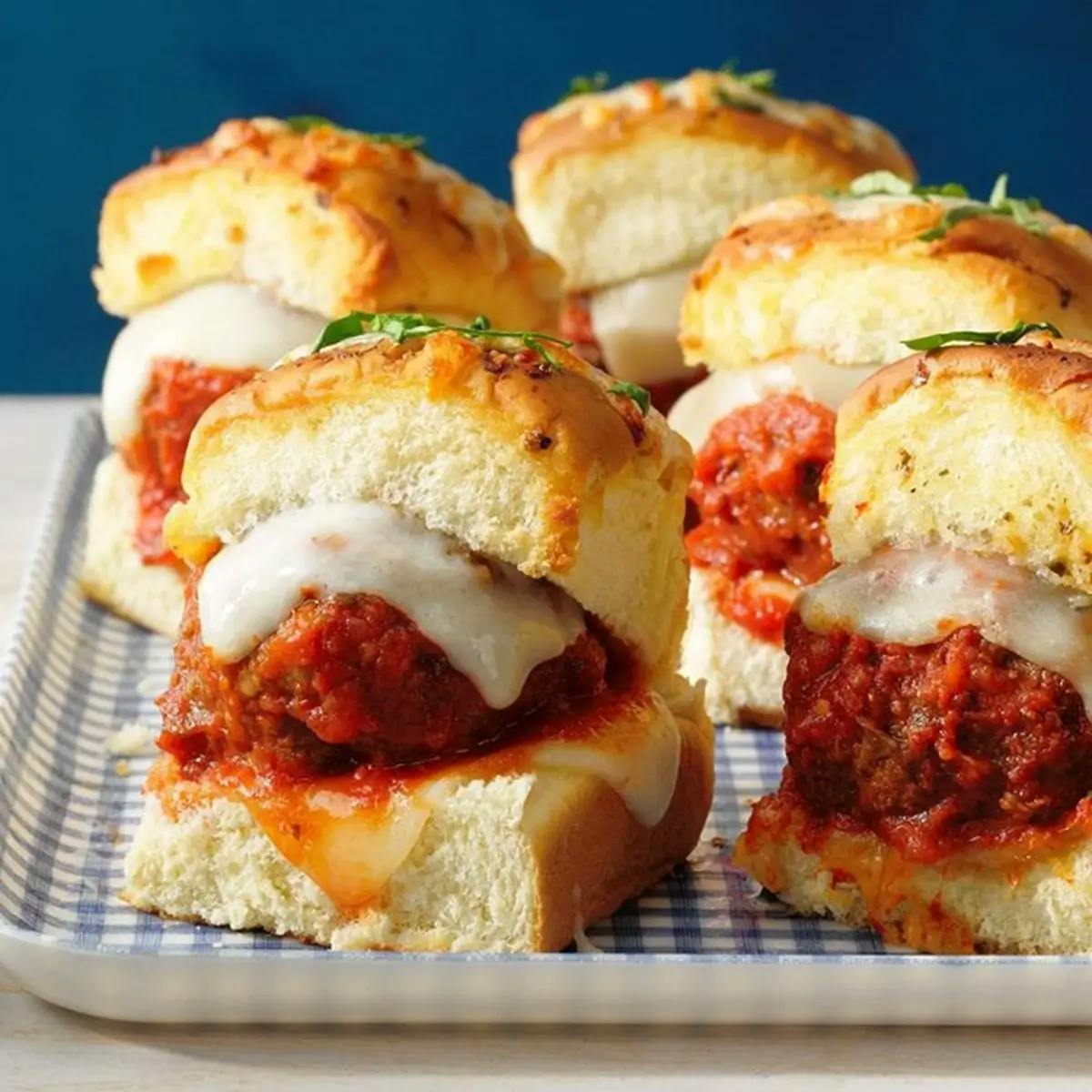 Meatball sliders at a Super Bowl party. Hawaiian rolls containing meatballs and mozzarella cheese.