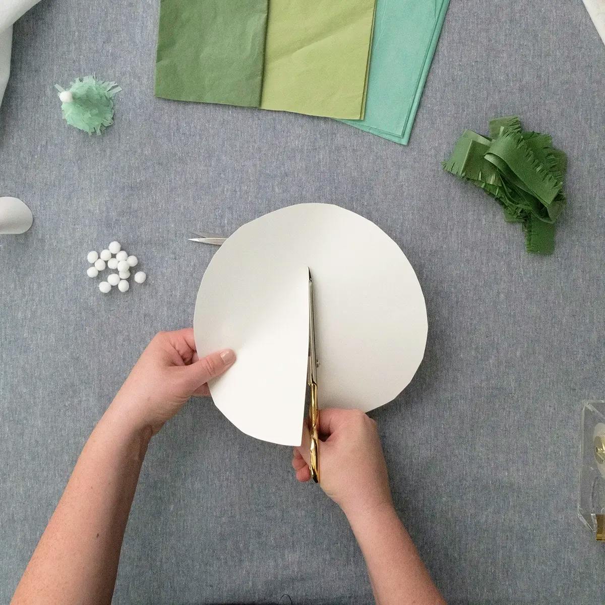 Cutting paper circles in half to create paper tree ornaments.