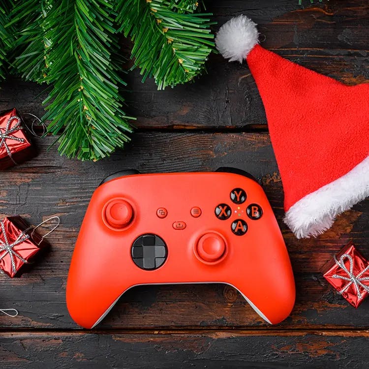 Red video game controller next to santa hat