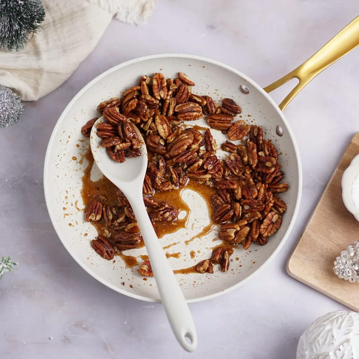 Coating pecans in a sweet syrup ready to add to a Christmas or Thanksgiving green salad recipe.