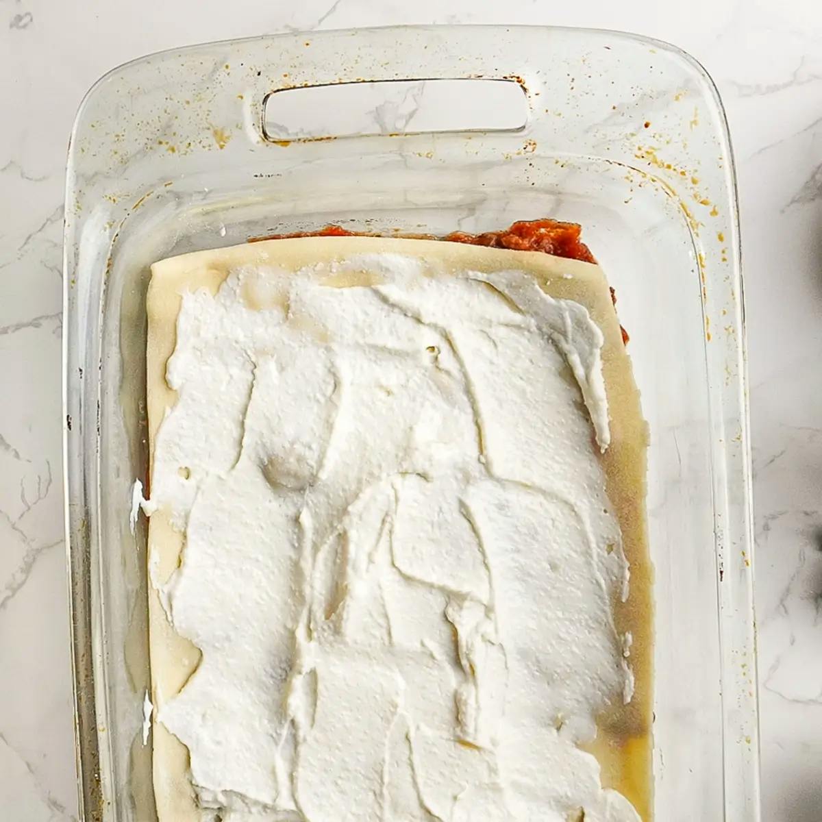 Layering vegan ground beef, homemade pasta, and vegan ricotta cheese in a vegan lasagna recipe.