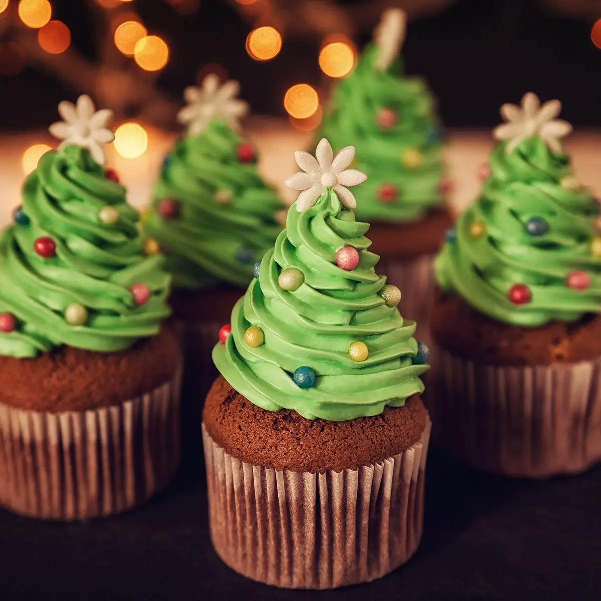 Chocolate cupcakes with green frosting shaped like Christmas trees.