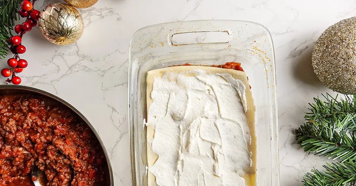 Layering vegan ground beef, homemade pasta, and vegan ricotta cheese in a vegan lasagna recipe.