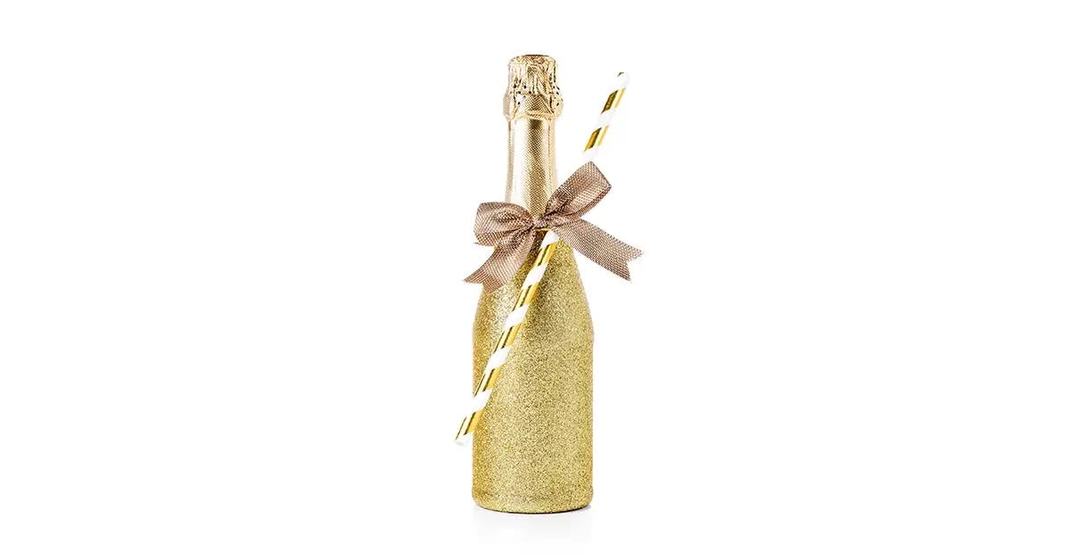A wine bottle dipped in glitter and tied with ribbon.