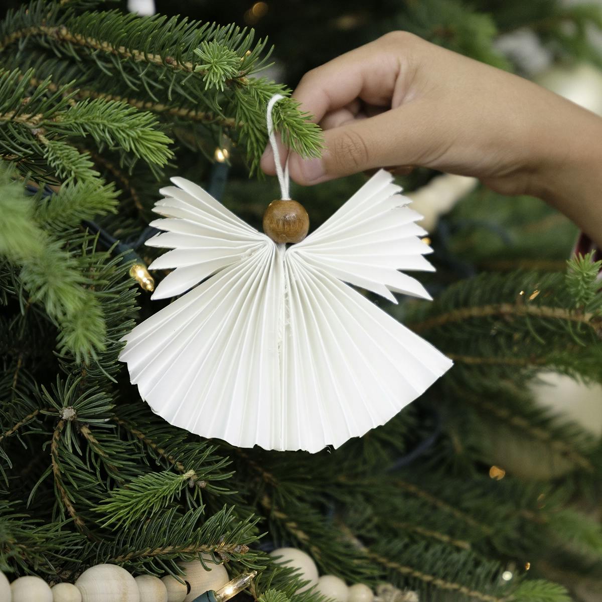 DIY angel Christmas ornament hanging on a tree.