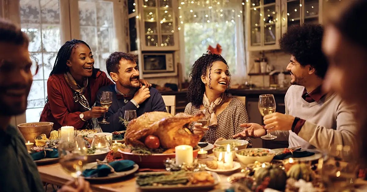 Multi-racial group of people eating Christas dinner and celebrating Christmas on a budget.