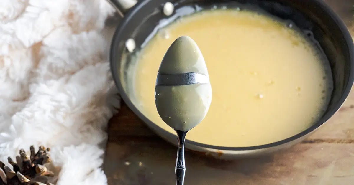Whisking homemade vegan vanilla pudding until it coats the back of a spoon.