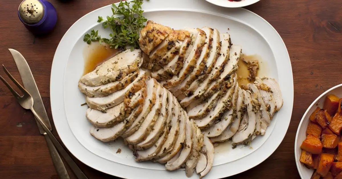Slices of herb-roasted turkey breast on a white plate.
