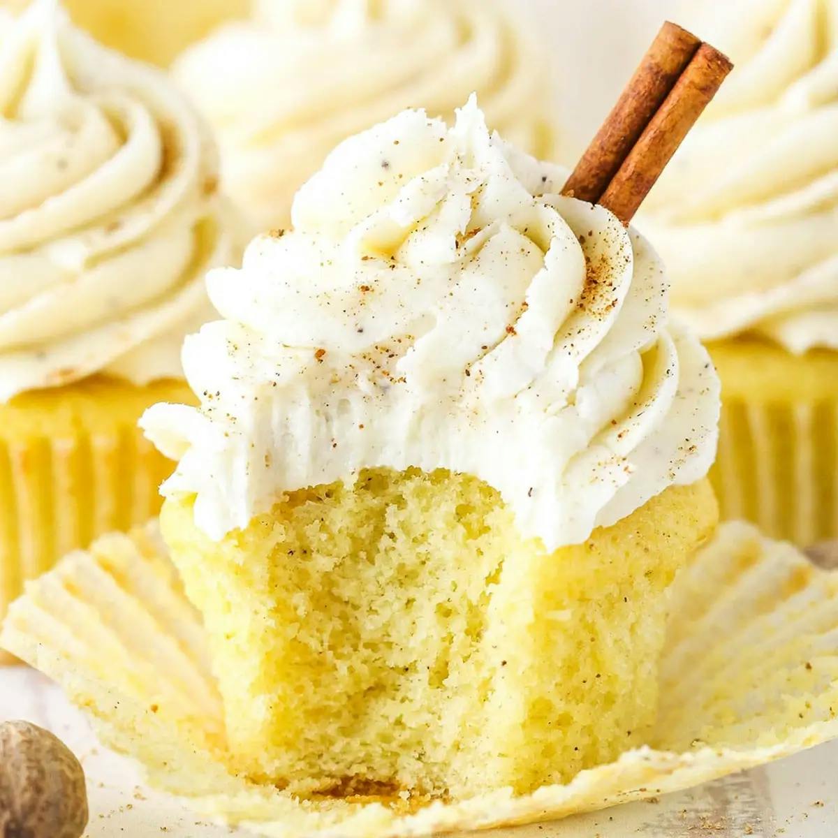 A yellow cupcake with white frosting, sprinkled with nutmeg.