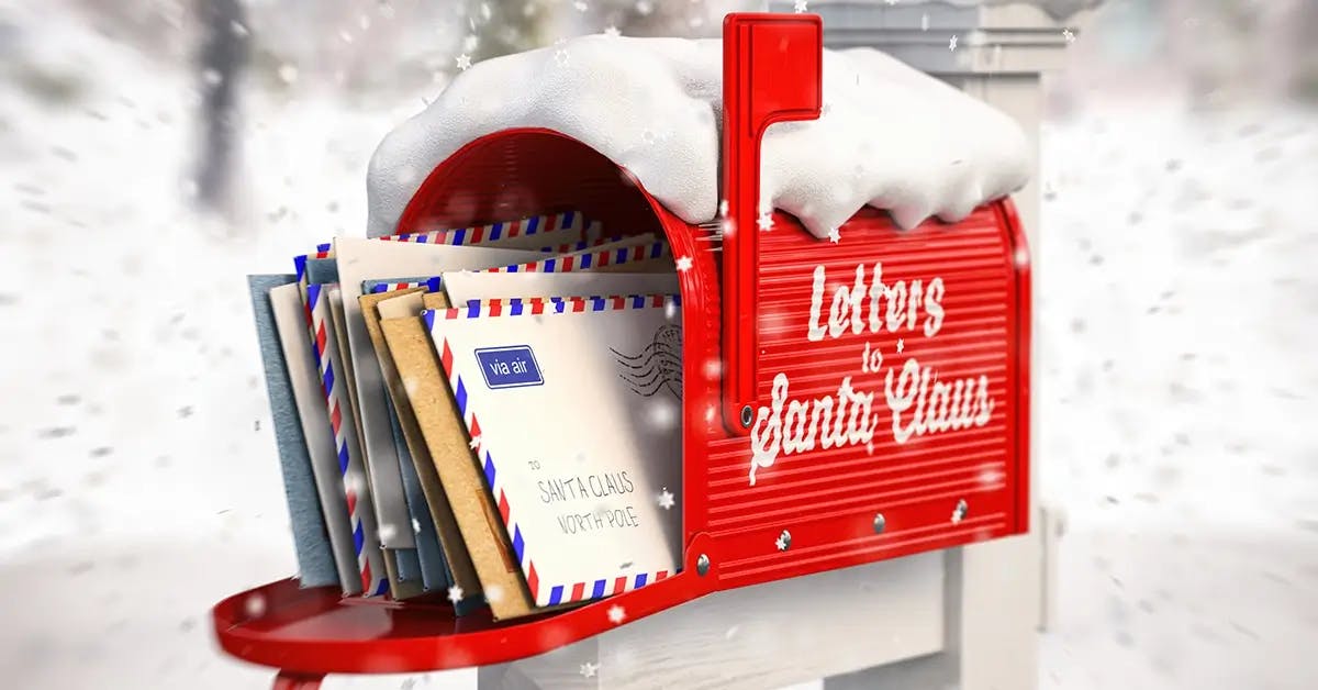 A red “Letters To Santa” mailbox with letters sticking out, surrounded by snow.
