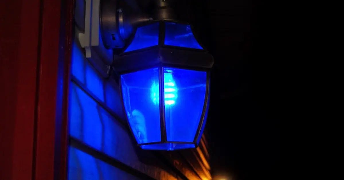 Close up of a blue bulb in a porch light on a front porch.