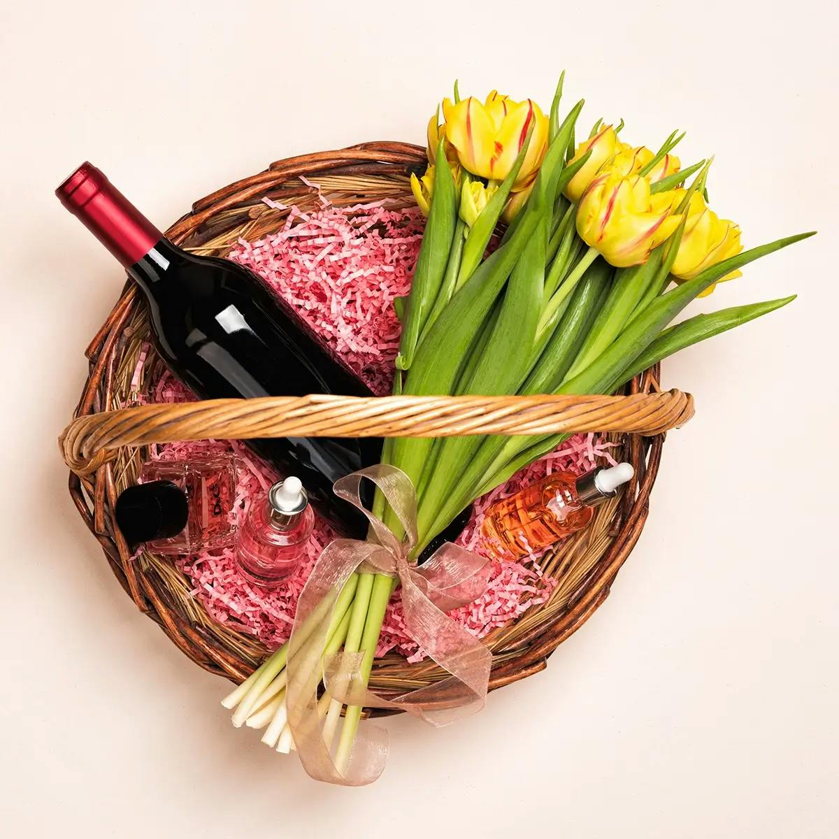 Easter basket for adults with wine, daffodils, and perfume.