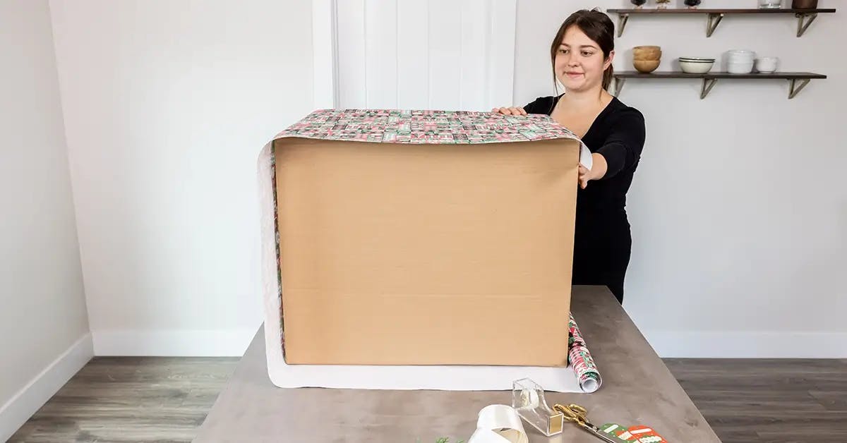 Securing wrapping paper to a large box.