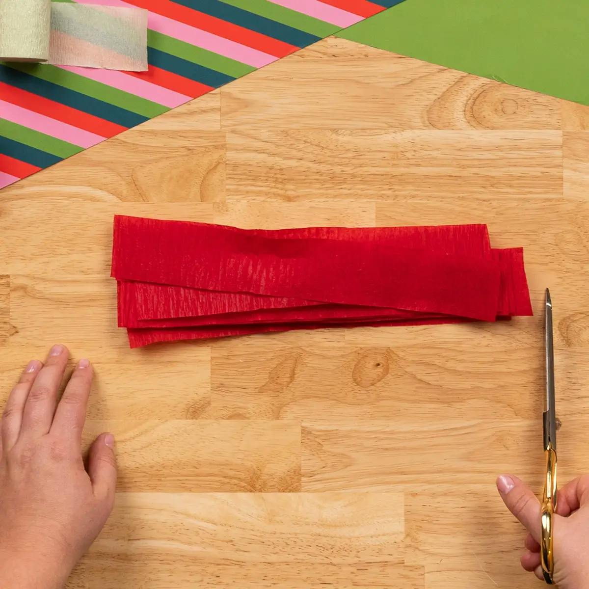 Cutting strips of crepe paper ready to wrap a mug as a Christmas gift.