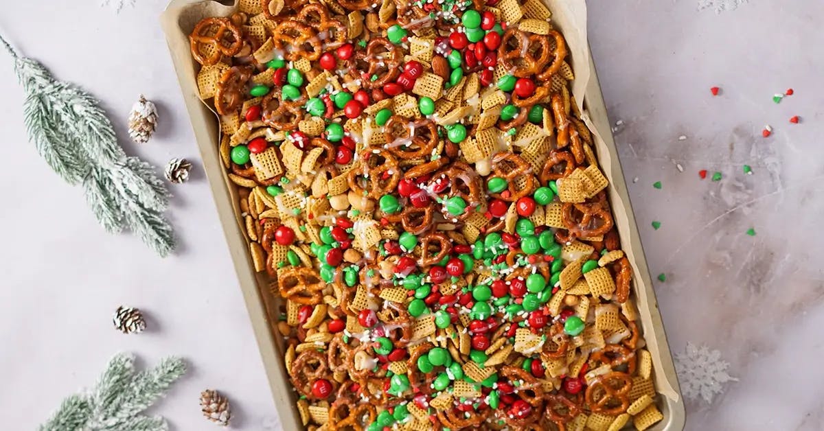 Melted white chocolate drizzled over homemade chex mix for Christmas.