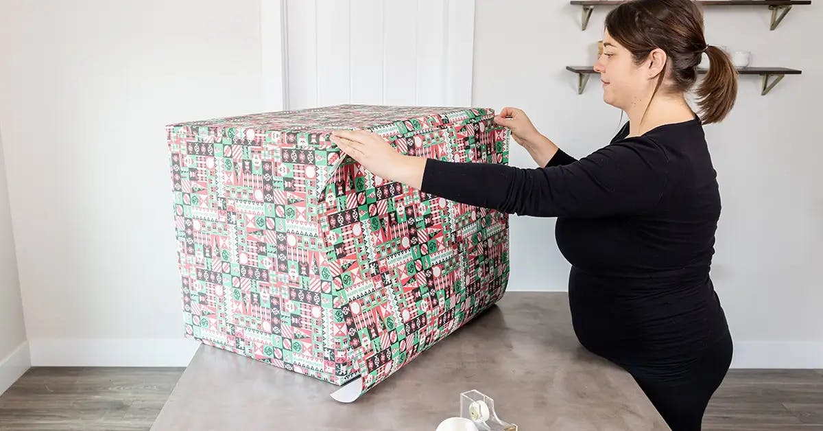 Adding extra wrapping paper to a large box.