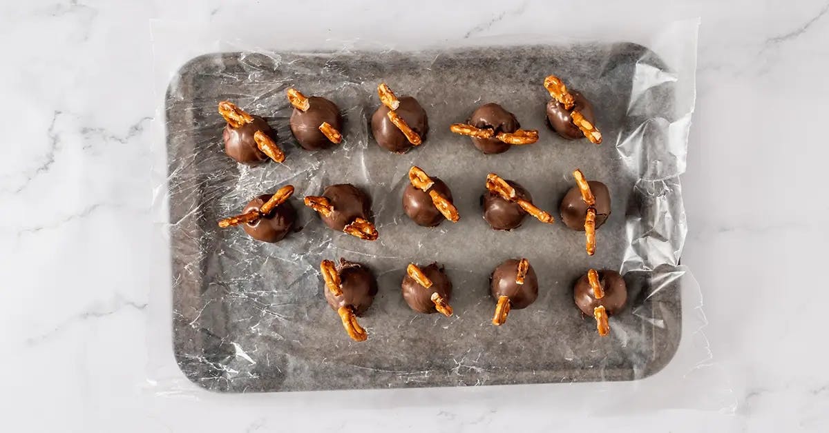 Cookie dough bites dipped in chocolate, with pretzel pieces stuck on top.