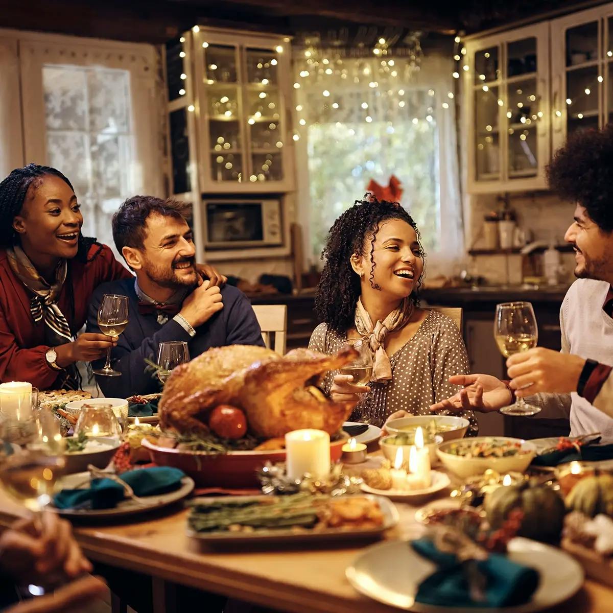 Multi-racial group of people eating Christas dinner and celebrating Christmas on a budget.
