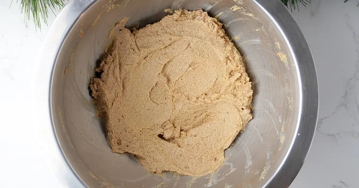 Folding dry flour mixture to batter in a vegan chocolate chip cookie recipe.
