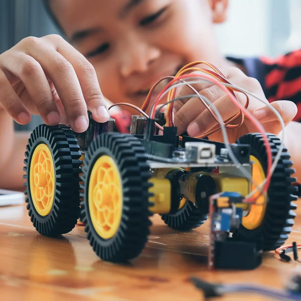 Child playing with STEM toy - robotic car kit